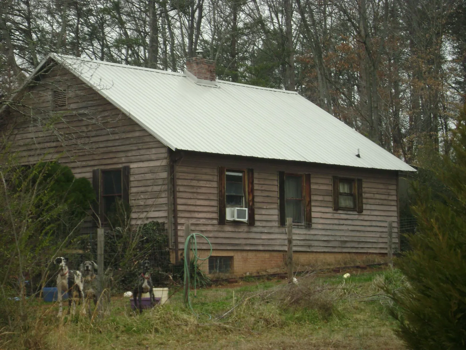 White metal roof on an old wood sided farmhouse, from a Metal Roof Installation job in Barboursville